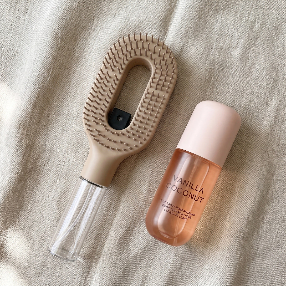 Brumelle Vanilla Coconut Scent Mist laid on linen beside the Brumelle Hydrating Brush in beige