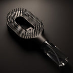 Brumelle Hydrating Brush in black, lit from above to show the clear refillable mist reservoir in the handle