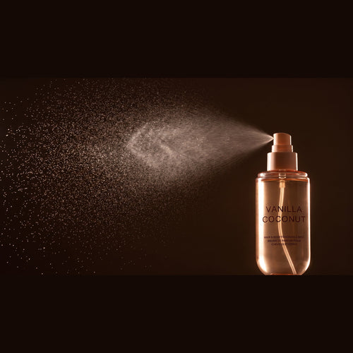 Brumelle Vanilla Coconut Scent Mist releasing a fine spray, close-up on a dark background